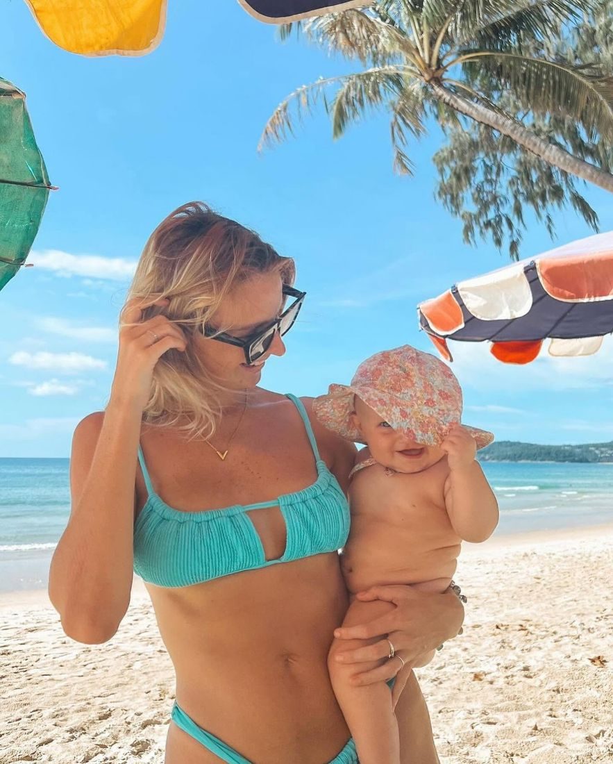 Original photo of a mother on the beach holding her baby in a sunhat