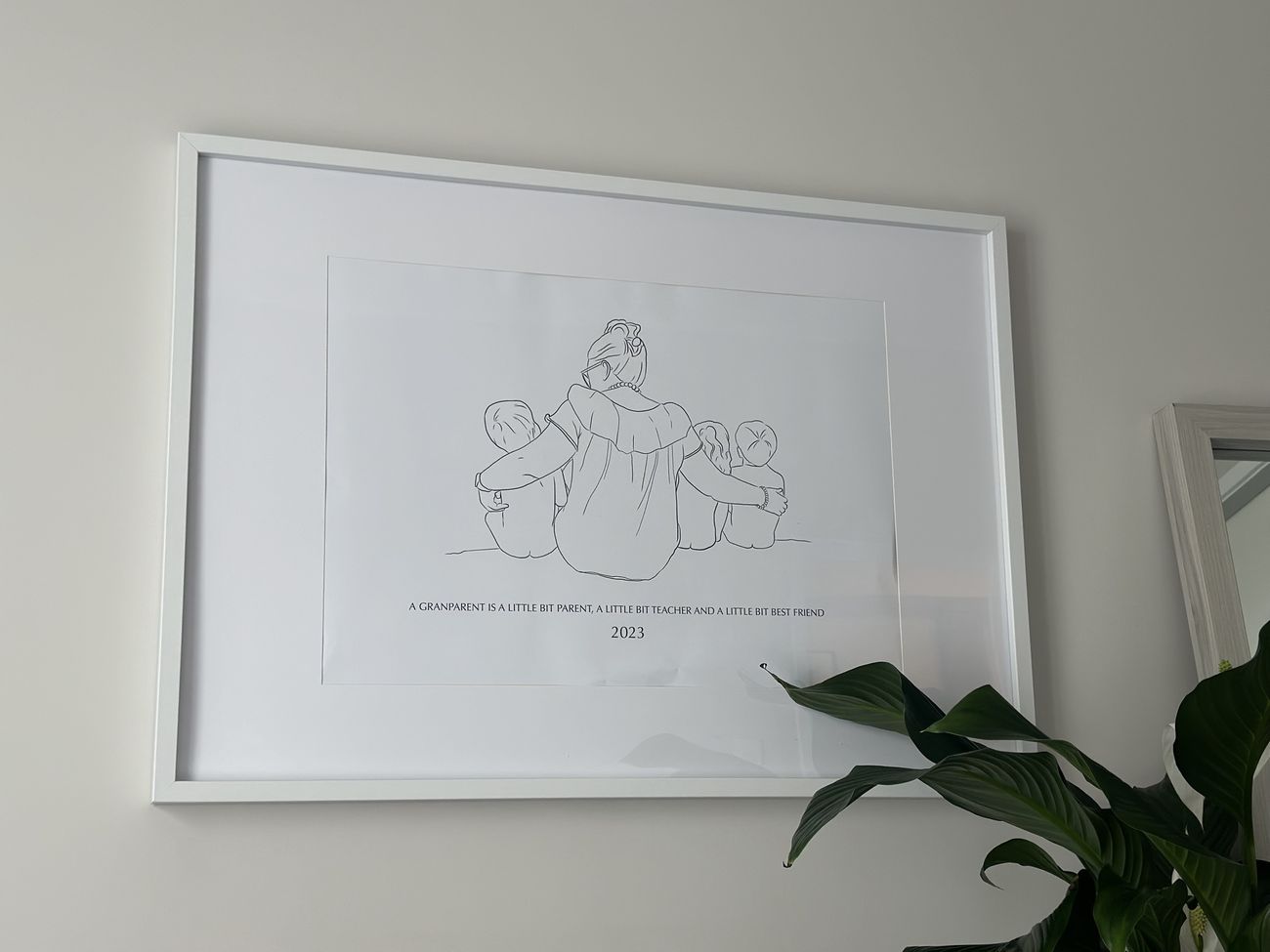 Grandparent line drawing in a white frame on a living room wall