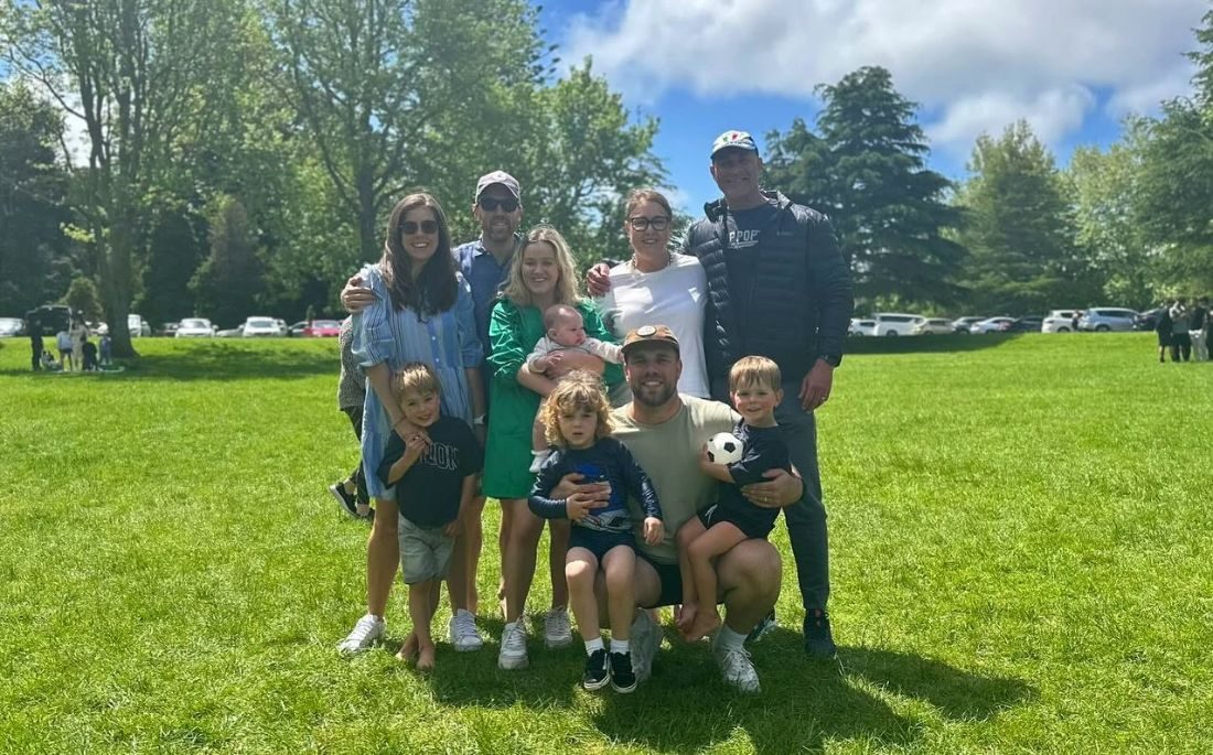 Original photo of a family of eleven standing together on a grassy park