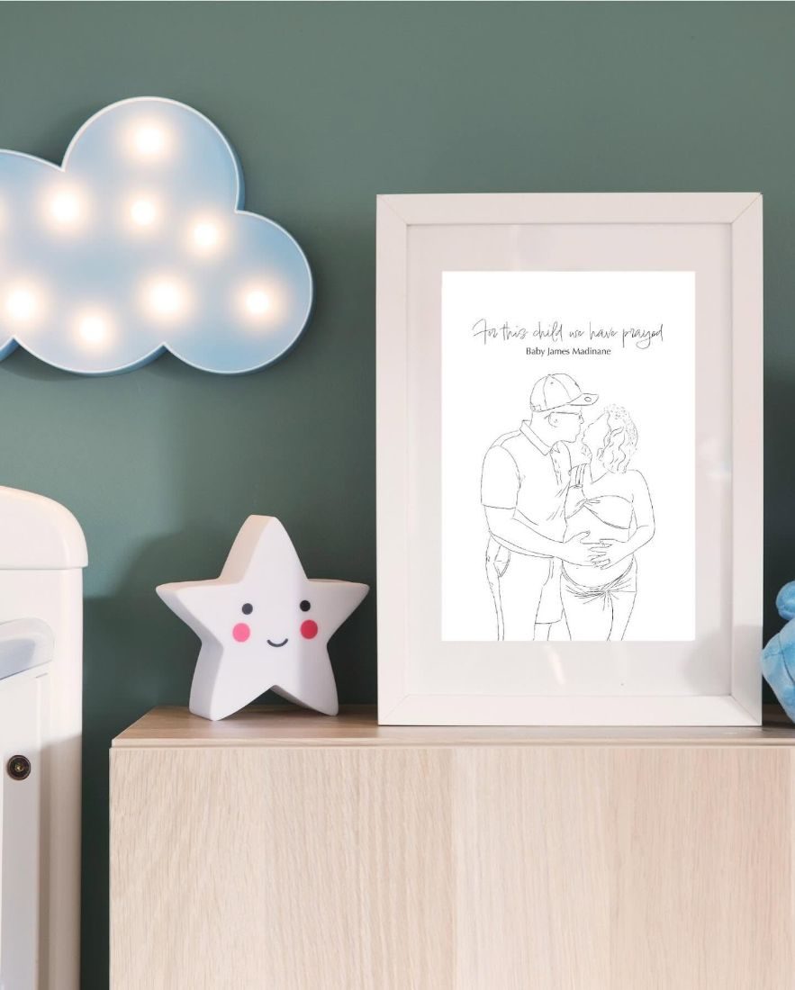 Baby James drawing framed in a nursery beside a cloud light and star